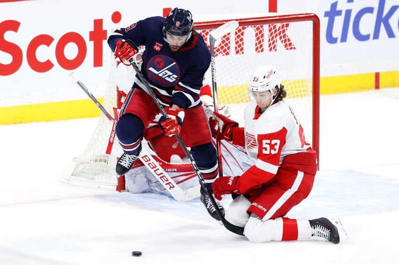 Dec 20, 2023; Winnipeg, Manitoba, CAN; Winnipeg Jets left wing Alex Iafallo (9) leaps on a shot as Detroit Red Wings defenseman Moritz Seider (53) tries to block the shot on Detroit Red Wings goaltender James Reimer (47) in the third period at Canada Life Centre. Mandatory Credit: James Carey Lauder-USA TODAY Sports