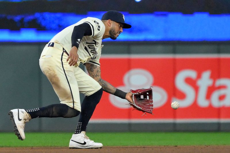 Jul 3, 2024; Minneapolis, Minnesota, USA; Minnesota Twins infielder Carlos Correa (4) fields a ground ball against the Detroit Tigers during the eighth inning at Target Field. Mandatory Credit: Nick Wosika-USA TODAY Sports