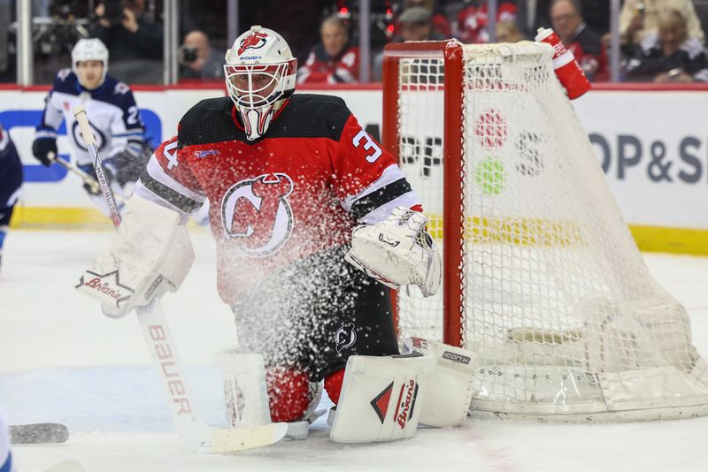 Mar 21, 2024; Newark, New Jersey, USA; New Jersey Devils goaltender Jake Allen (34) defends his net against the Winnipeg Jets during the first period at Prudential Center. Mandatory Credit: Ed Mulholland-USA TODAY Sports