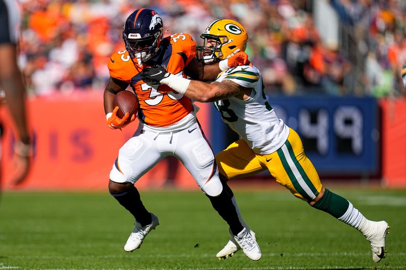 Denver Broncos running back Javonte Williams (33) is tackled by Green Bay Packers linebacker Isaiah McDuffie (58) during an NFL football game Sunday, Oct. 22, 2023, in Denver. (AP Photo/Jack Dempsey)