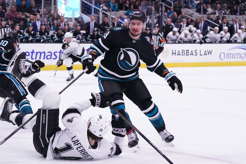 Oct 28, 2025; San Jose, California, USA; San Jose Sharks defenseman Dmitry Orlov (9) puts Los Angeles Kings right winger Alex Laferriere (14) on the ice in the first period at SAP Center at San Jose. Mandatory Credit: David Gonzales-Imagn Images
