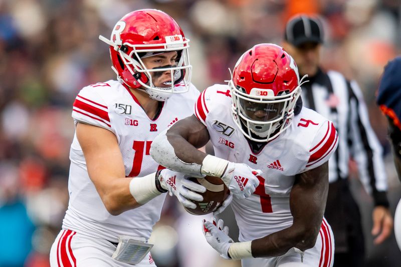 Nov 2, 2019; Champaign, IL, USA; Rutgers Scarlet Knights quarterback Johnny Langan (left) fakes a hand off to running back Aaron Young (right) during the first half against the Illinois Fighting Illini at Memorial Stadium. Mandatory Credit: Patrick Gorski-USA TODAY Sports