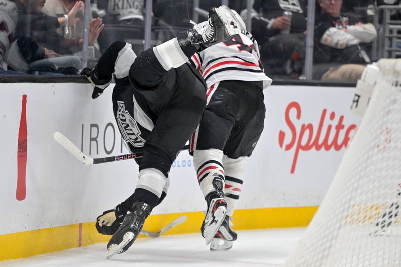 Dec 4, 2025; Los Angeles, California, USA;  Los Angeles Kings left wing Kevin Fiala (22) is upended by Chicago Blackhawks defenseman Wyatt Kaiser (44) during the second period at Crypto.com Arena. Mandatory Credit: Jayne Kamin-Oncea-Imagn Images