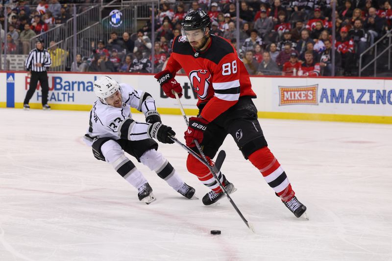 Feb 23, 2023; Newark, New Jersey, USA; New Jersey Devils defenseman Kevin Bahl (88) plays the puck while being defended by Los Angeles Kings right wing Viktor Arvidsson (33) during the first period at Prudential Center. Mandatory Credit: Ed Mulholland-USA TODAY Sports