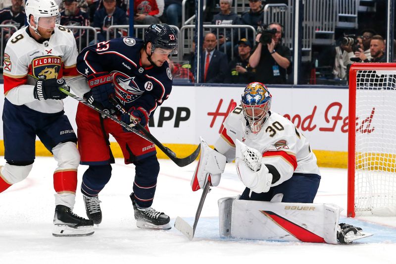 Oct 15, 2024; Columbus, Ohio, USA; Florida Panthers goalie Spencer Knight (30) makes a glove save as Columbus Blue Jackets center Sean Monahan (23) looks for a rebound during the second period at Nationwide Arena. Mandatory Credit: Russell LaBounty-Imagn Images