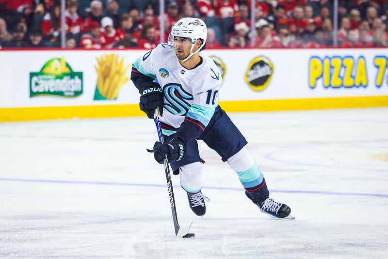 Dec 27, 2023; Calgary, Alberta, CAN; Seattle Kraken center Matty Beniers (10) skates with the puck against the Calgary Flames during the third period at Scotiabank Saddledome. Mandatory Credit: Sergei Belski-USA TODAY Sports