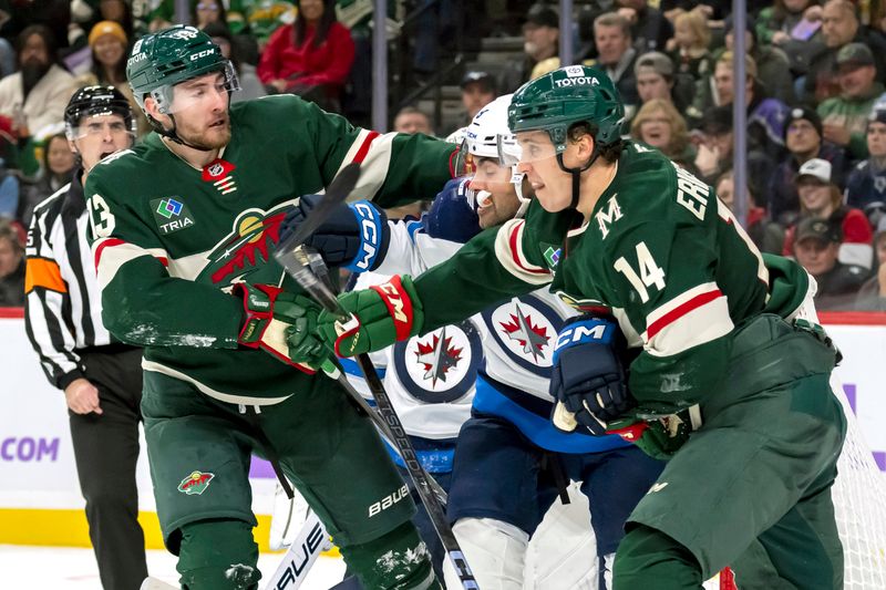 Nov 25, 2024; Saint Paul, Minnesota, USA;  Minnesota Wild forward Yakov Trenin (13) and forward Joel Eriksson Ek (14) get tied up with Winnipeg Jets forward Alex Iafallo (9) during the second period at Xcel Energy Center. Mandatory Credit: Nick Wosika-Imagn Images