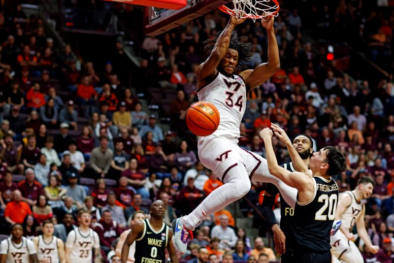 Mar 2, 2024; Blacksburg, Virginia, USA; Virginia Tech Hokies forward Mylyjael Poteat (34) dunks the ball against Wake Forest Demon Deacons guard Parker Friedrichsen (20) during the second half at Cassell Coliseum. Mandatory Credit: Peter Casey-USA TODAY Sports