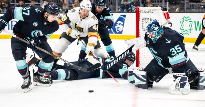 Nov 8, 2024; Seattle, Washington, USA;  Seattle Kraken goalie Joey Daccord (35), defenseman Jamie Oleksiak (24) forward Yanni Gourde (37) and Vegas Golden Knights forward Tomas Hertl (48) battle for a loose puck during the first period at Climate Pledge Arena. Mandatory Credit: Stephen Brashear-Imagn Images