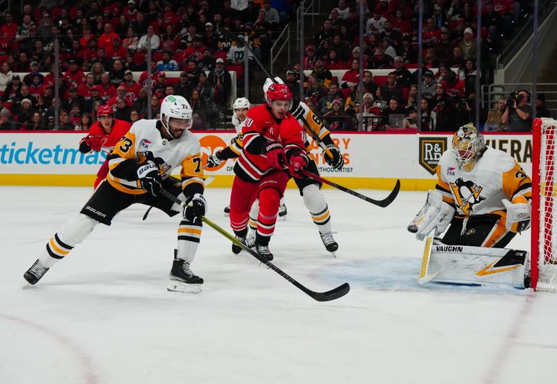 Jan 13, 2024; Raleigh, North Carolina, USA;  Pittsburgh Penguins goaltender Tristan Jarry (35) defenseman Pierre-Olivier Joseph (73) and Carolina Hurricanes center Sebastian Aho (20) watch the shot during the first period at PNC Arena. Mandatory Credit: James Guillory-USA TODAY Sports