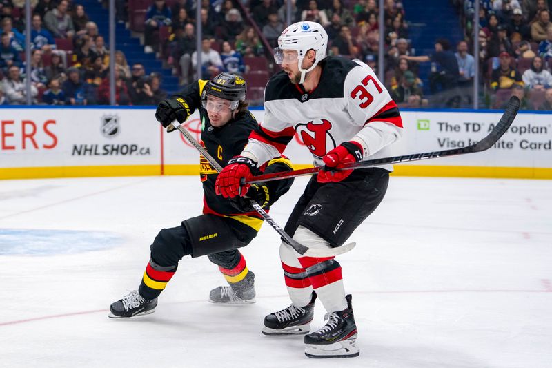 Oct 30, 2024; Vancouver, British Columbia, CAN; Vancouver Canucks defenseman Quinn Hughes (43) battles with New Jersey Devils forward Justin Dowling (37) during the first period at Rogers Arena. Mandatory Credit: Bob Frid-Imagn Images