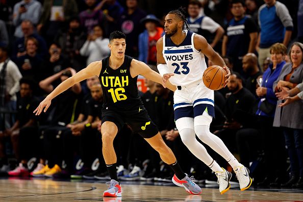 MINNEAPOLIS, MINNESOTA - NOVEMBER 30: Troy Brown Jr. #23 of the Minnesota Timberwolves dribbles the ball while Simone Fontecchio #16 of the Utah Jazz defends in the first quarter at Target Center on November 30, 2023 in Minneapolis, Minnesota. NOTE TO USER: User expressly acknowledges and agrees that, by downloading and or using this photograph, User is consenting to the terms and conditions of the Getty Images License Agreement. (Photo by David Berding/Getty Images)