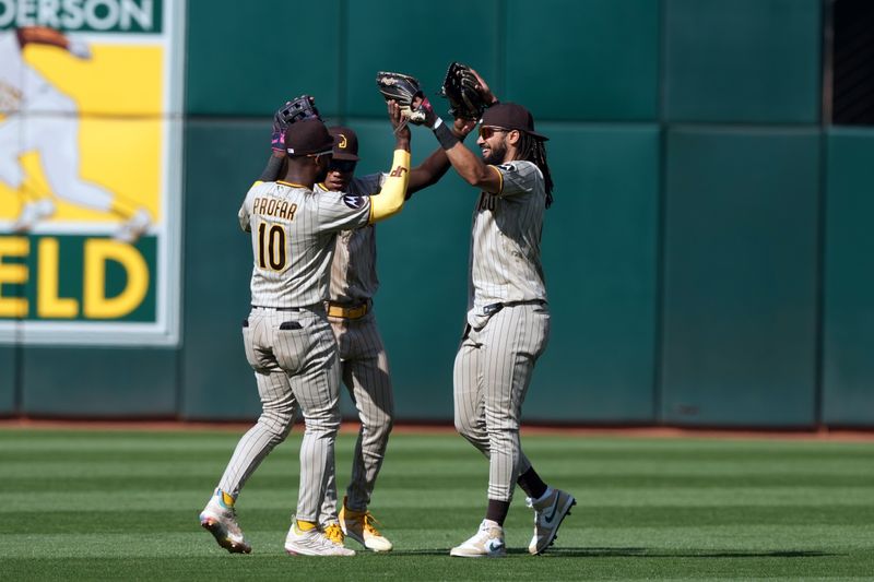 Sep 17, 2023; Oakland, California, USA; San Diego Padres left fielder Jurickson Profar (10) celebrates with center fielder Jose Azocar (center) and right fielder Fernando Tatis Jr. (right) after defeating the Oakland Athletics at Oakland-Alameda County Coliseum. Mandatory Credit: Darren Yamashita-USA TODAY Sports