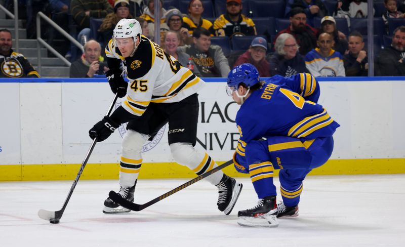 Jan 28, 2025; Buffalo, New York, USA;  Boston Bruins left wing Cole Koepke (45) looks to make a pass as Buffalo Sabres defenseman Bowen Byram (4) defends during the first period at KeyBank Center. Mandatory Credit: Timothy T. Ludwig-Imagn Images