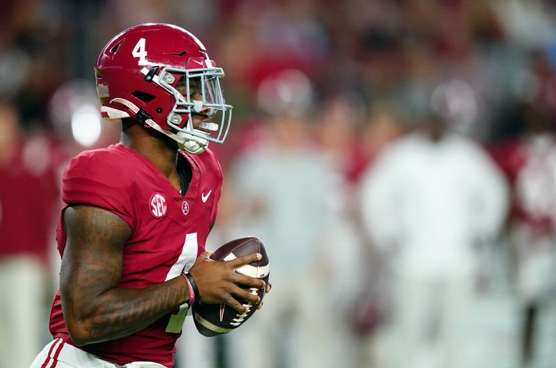 Nov 4, 2023; Tuscaloosa, Alabama, USA; Alabama Crimson Tide quarterback Jalen Milroe (4) rolls out to pass against the LSU Tigers during the first quarter at Bryant-Denny Stadium. Mandatory Credit: John David Mercer-USA TODAY Sports