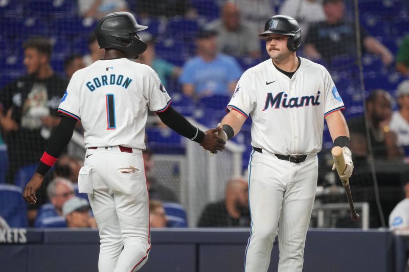 Jun 4, 2024; Miami, Florida, USA; Miami Marlins third baseman Jake Burger (36) congratulates left fielder Nick Gordon (1) after scoring a run in the seventh inning against the Tampa Bay Rays at loanDepot Park. Mandatory Credit: Jim Rassol-USA TODAY Sports