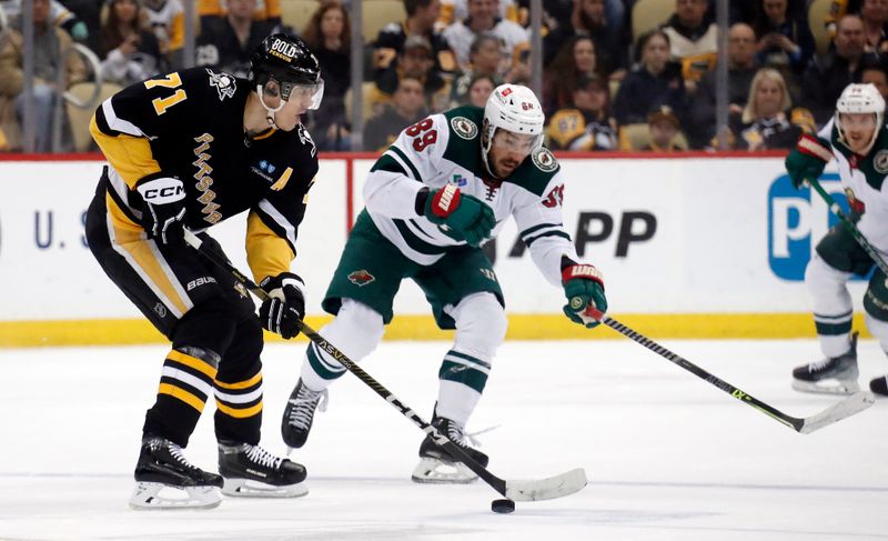 Apr 6, 2023; Pittsburgh, Pennsylvania, USA; Pittsburgh Penguins center Evgeni Malkin (71) moves the puck against Minnesota Wild center Frederick Gaudreau (89) during the first period at PPG Paints Arena. Mandatory Credit: Charles LeClaire-USA TODAY Sports