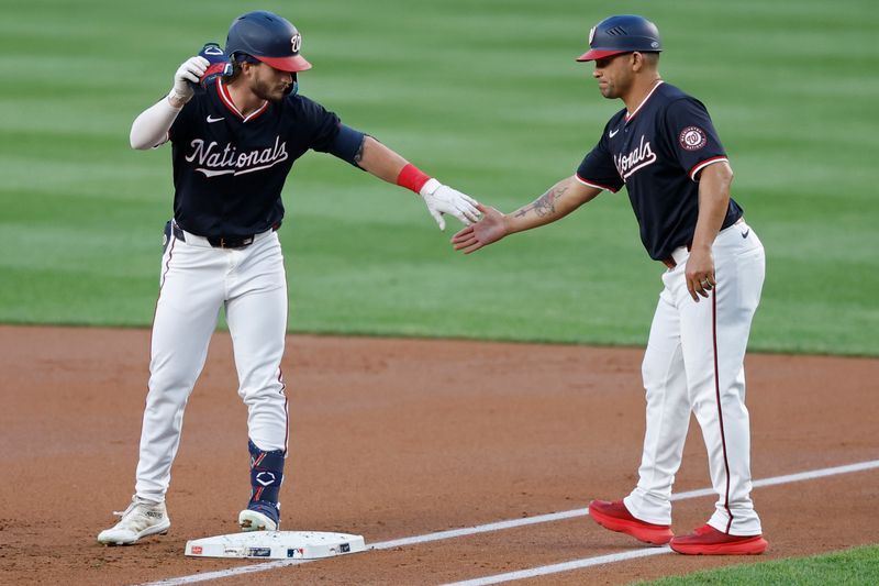 Sep 11, 2024; Washington, District of Columbia, USA; Washington Nationals outfielder Dylan Crews (3) celebrates at first base with Nationals first base coach Gerardo Parra (88) after hitting a single against the Atlanta Braves during the first inning at Nationals Park. Mandatory Credit: Geoff Burke-Imagn Images