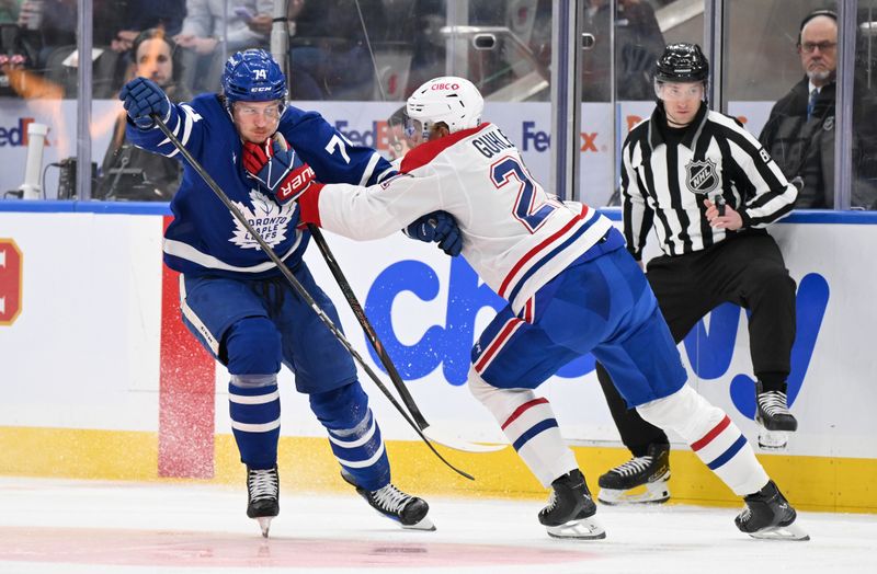 Apr 12, 2025; Toronto, Ontario, CAN;  Toronto Maple Leafs forward Bobby McMann (74) tries to get past Montreal Canadiens defenseman Kaiden Guhle (21) in the first period at Scotiabank Arena. Mandatory Credit: Dan Hamilton-Imagn Images