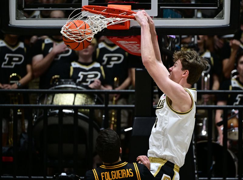 Jan 14, 2026; West Lafayette, Indiana, USA; Purdue Boilermakers center Daniel Jacobsen (12) dunks the ball in front of Iowa Hawkeyes forward Alvaro Folgueiras (7) during the first half at Mackey Arena. Mandatory Credit: Marc Lebryk-Imagn Images