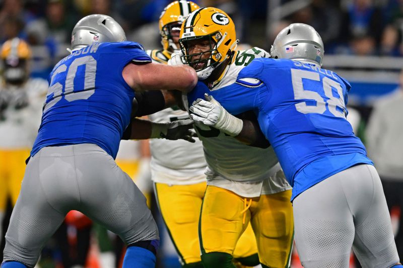 Green Bay Packers defensive tackle Kenny Clark is blocked by Detroit Lions offensive tackle Penei Sewell and guard Graham Glasgow during the second half of an NFL football game, Thursday, Nov. 23, 2023, in Detroit. The Packers won 29-22. (AP Photo/David Dermer)