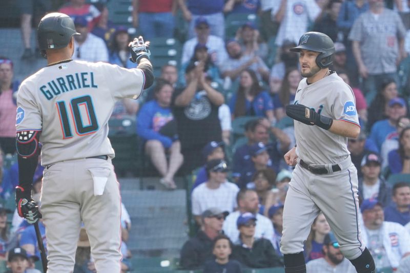 May 7, 2023; Chicago, Illinois, USA; Miami Marlins pinch-runner Garrett Hampson (1) scores on a balk and is greeted by first baseman Yuli Gurriel (10) against the Chicago Cubs during the fourteenth inning at Wrigley Field. Mandatory Credit: David Banks-USA TODAY Sports