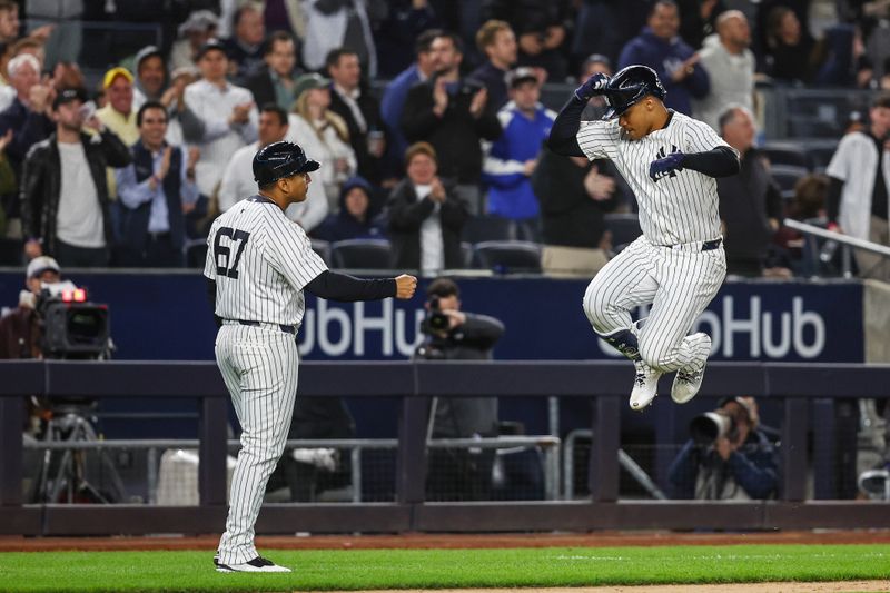 Apr 24, 2024; Bronx, New York, USA; New York Yankees right fielder Juan Soto (22) celebrates with third base coach Luis Rojas (67) after hitting a solo home run in the sixth inning against the Oakland Athletics at Yankee Stadium. Mandatory Credit: Wendell Cruz-USA TODAY Sports