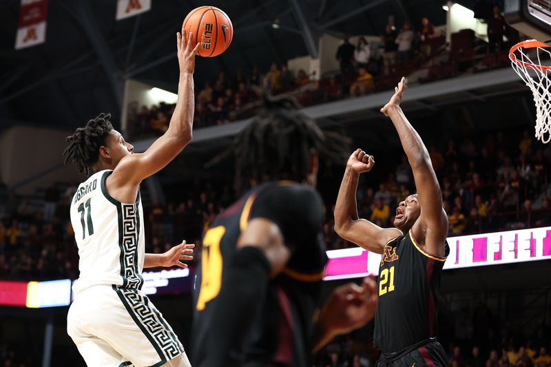 Feb 6, 2024; Minneapolis, Minnesota, USA; Michigan State Spartans guard A.J. Hoggard (11) shoots as Minnesota Golden Gophers forward Pharrel Payne (21) defends during the second half at Williams Arena. Mandatory Credit: Matt Krohn-USA TODAY Sports