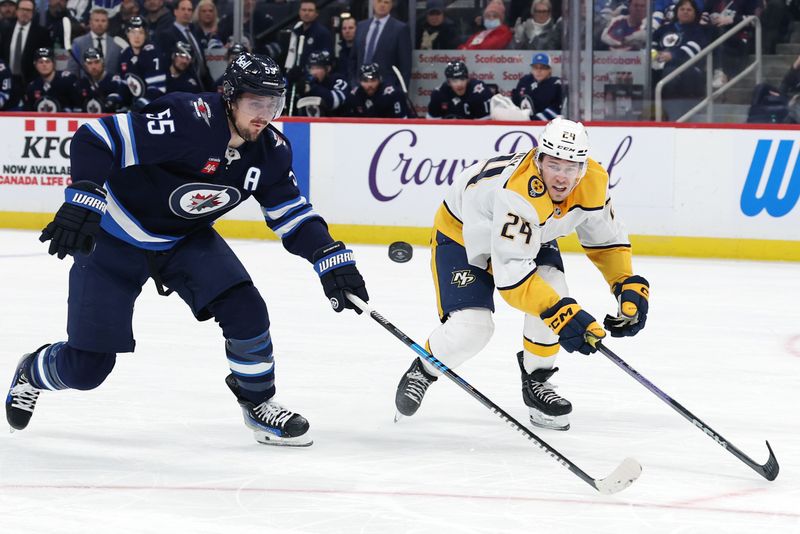 Jan 7, 2025; Winnipeg, Manitoba, CAN; Winnipeg Jets center Mark Scheifele (55) and Nashville Predators defenseman Spencer Stastney (24) eye a bouncing puck in the second period at Canada Life Centre. Mandatory Credit: James Carey Lauder-Imagn Images