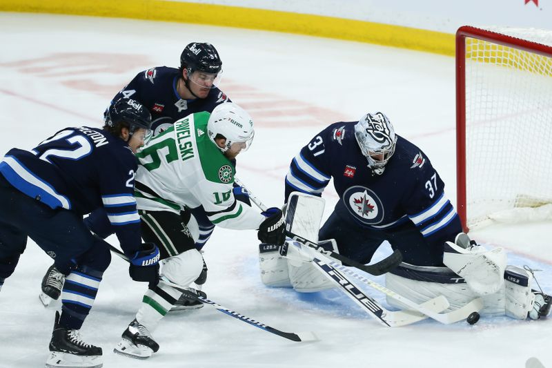 Nov 11, 2023; Winnipeg, Manitoba, CAN;  Winnipeg Jets goalie Connor Hellebuyck (37) stops Dallas Stars forward Joe Pavelski (16) during the third period at Canada Life Centre. Mandatory Credit: Terrence Lee-USA TODAY Sports