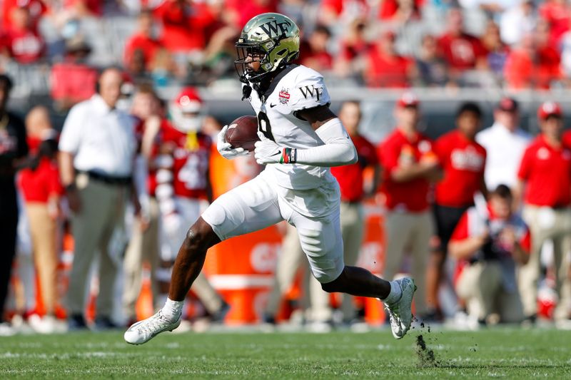 Dec 31, 2021; Jacksonville, Florida, USA;  Wake Forest Demon Deacons wide receiver A.T. Perry (9) runs with the ball in the second half against the Rutgers Scarlet Knights      at TIAA Bank Field. Mandatory Credit: Nathan Ray Seebeck-USA TODAY Sports