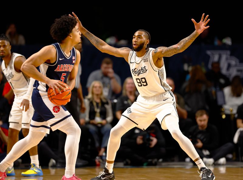 Jan 17, 2026; Orlando, Florida, USA;  Central Florida Knights forward Jordan Burks (99) defends Arizona Wildcats guard Brayden Burries (5) in the first half at Addition Financial Arena. Mandatory Credit: Russell Lansford-Imagn Images