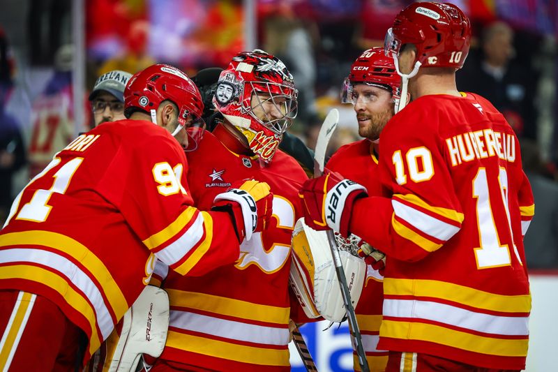 Nov 15, 2024; Calgary, Alberta, CAN; Calgary Flames goaltender Dustin Wolf (32) celebrate win with teammates after defeating Nashville Predators at Scotiabank Saddledome. Mandatory Credit: Sergei Belski-Imagn Images