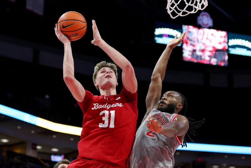 Feb 17, 2026; Columbus, Ohio, USA; Wisconsin Badgers forward Nolan Winter (31) drives to the basket as Ohio State Buckeyes guard Bruce Thornton (2) defends during the first half at Value City Arena. Mandatory Credit: Joseph Maiorana-Imagn Images