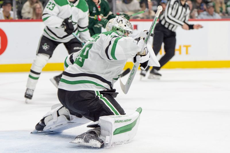 Apr 6, 2025; Saint Paul, Minnesota, USA; A Minnesota Wild shot goes just over the shoulder of Dallas Stars goaltender Jake Oettinger (29) in the second period at Xcel Energy Center. Mandatory Credit: Matt Blewett-Imagn Images