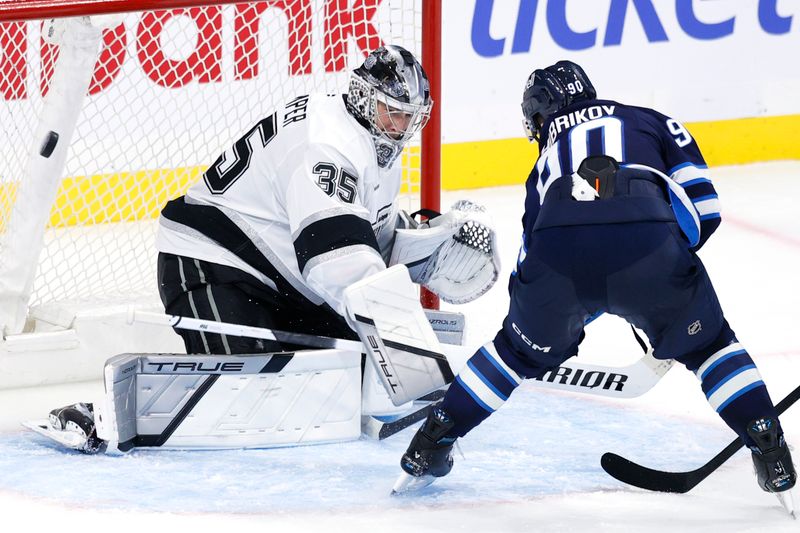 Oct 11, 2025; Winnipeg, Manitoba, CAN; Los Angeles Kings goaltender Darcy Kuemper (35) blocks a shot from Winnipeg Jets right wing Nikita Chibrikov (90) in the third period at Canada Life Centre. Mandatory Credit: James Carey Lauder-Imagn Images