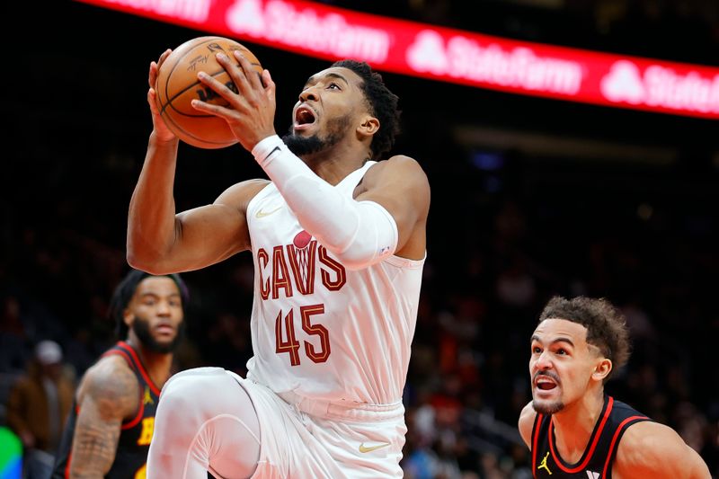 ATLANTA, GEORGIA - JANUARY 20: Donovan Mitchell #45 of the Cleveland Cavaliers drives to the basket over Trae Young #11 of the Atlanta Hawks during the first half at State Farm Arena on January 20, 2024 in Atlanta, Georgia. NOTE TO USER: User expressly acknowledges and agrees that, by downloading and or using this photograph, User is consenting to the terms and conditions of the Getty Images License Agreement. (Photo by Alex Slitz/Getty Images)