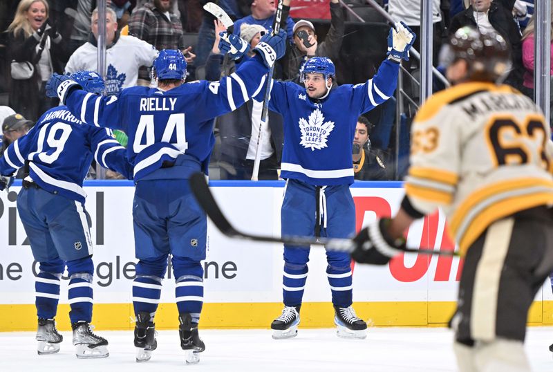 Dec 2, 2023; Toronto, Ontario, CAN; Toronto Maple Leafs forward Auston Matthews (34) celebrates with defenseman Morgan Rielly (44) and forward Calle Jarnkrok (19) after scoring against the Boston Bruins in the third period at Scotiabank Arena. Mandatory Credit: Dan Hamilton-USA TODAY Sports