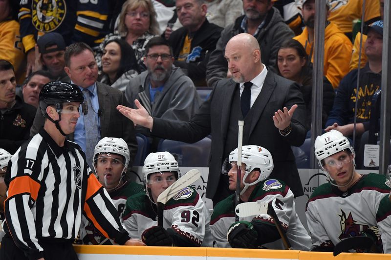 Feb 10, 2024; Nashville, Tennessee, USA; Arizona Coyotes head coach Andre Tourigny talks with referee Frederick L'Ecuyer (17) during the second period against the Nashville Predators at Bridgestone Arena. Mandatory Credit: Christopher Hanewinckel-USA TODAY Sports