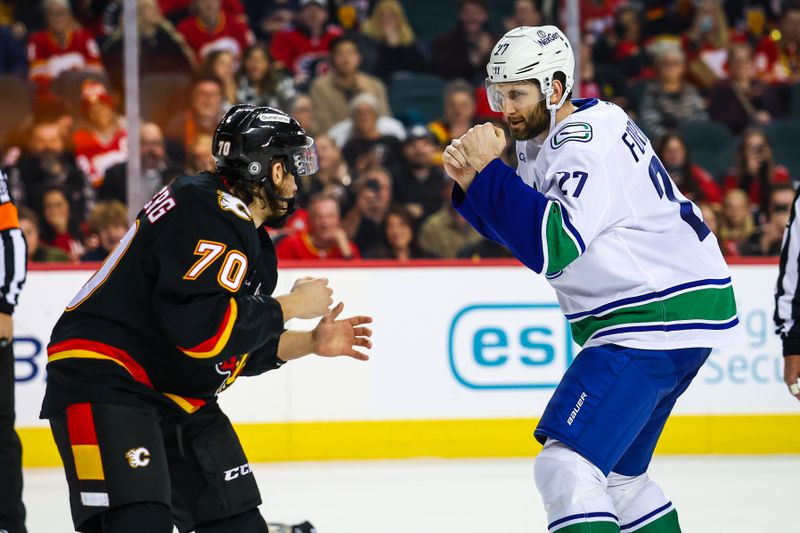 Dec 31, 2024; Calgary, Alberta, CAN; Vancouver Canucks defenseman Derek Forbort (27) and Calgary Flames left wing Ryan Lomberg (70) fights during the second period at Scotiabank Saddledome. Mandatory Credit: Sergei Belski-Imagn Images