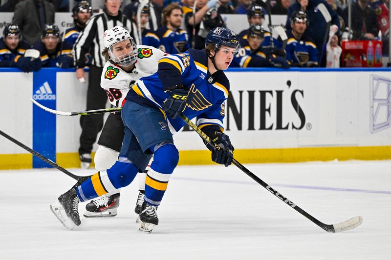 Apr 10, 2024; St. Louis, Missouri, USA;  St. Louis Blues center Zach Dean (52) skates against Chicago Blackhawks center Connor Bedard (98) during the first period at Enterprise Center. Mandatory Credit: Jeff Curry-USA TODAY Sports