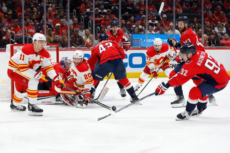 Oct 16, 2023; Washington, District of Columbia, USA; Calgary Flames center Mikael Backlund (11) and Washington Capitals center Evgeny Kuznetsov (92) battle for the puck in front of Capitals goaltender Darcy Kuemper (35) in the second period at Capital One Arena. Mandatory Credit: Geoff Burke-USA TODAY Sports