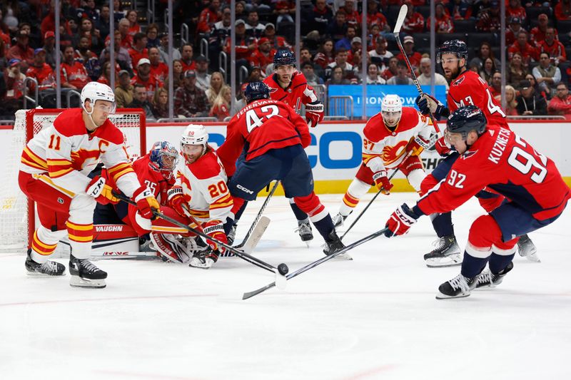 Oct 16, 2023; Washington, District of Columbia, USA; Calgary Flames center Mikael Backlund (11) and Washington Capitals center Evgeny Kuznetsov (92) battle for the puck in front of Capitals goaltender Darcy Kuemper (35) in the second period at Capital One Arena. Mandatory Credit: Geoff Burke-USA TODAY Sports