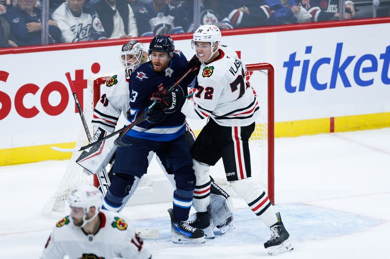 Oct 11, 2024; Winnipeg, Manitoba, CAN; Chicago Blackhawks defenseman Alex Vlasic (72) jostles for position with Winnipeg Jets forward Gabriel Vilardi (13) in front of Chicago Blackhawks goalie Arvid Soderblom (40) during the third period at Canada Life Centre. Mandatory Credit: Terrence Lee-Imagn Images