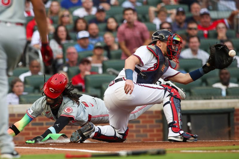 Jul 22, 2024; Atlanta, Georgia, USA; Cincinnati Reds shortstop Elly De La Cruz (44) slides safely past Atlanta Braves catcher Sean Murphy (12) in the first inning at Truist Park. Mandatory Credit: Brett Davis-USA TODAY Sports