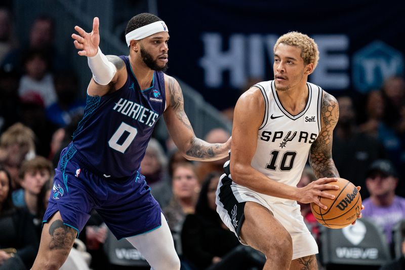 CHARLOTTE, NORTH CAROLINA - JANUARY 19: Miles Bridges #0 of the Charlotte Hornets guards Jeremy Sochan #10 of the San Antonio Spurs in the third quarter during their game at Spectrum Center on January 19, 2024 in Charlotte, North Carolina. NOTE TO USER: User expressly acknowledges and agrees that, by downloading and or using this photograph, User is consenting to the terms and conditions of the Getty Images License Agreement. (Photo by Jacob Kupferman/Getty Images)