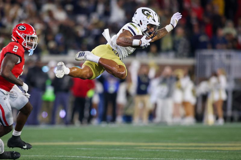 Nov 25, 2023; Atlanta, Georgia, USA; Georgia Tech Yellow Jackets running back Dontae Smith (4) dives during a run against the Georgia Bulldogs in the second half at Bobby Dodd Stadium at Hyundai Field. Mandatory Credit: Brett Davis-USA TODAY Sports