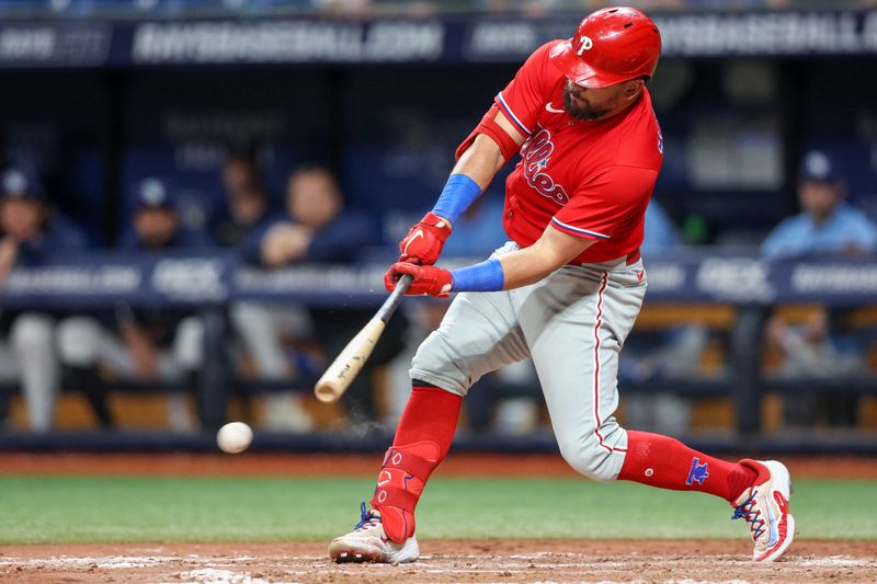 Jul 6, 2023; St. Petersburg, Florida, USA;  Philadelphia Phillies left fielder Kyle Schwarber (12) hits an rbi single against the Tampa Bay Rays in the eleventh inning at Tropicana Field. Mandatory Credit: Nathan Ray Seebeck-USA TODAY Sports