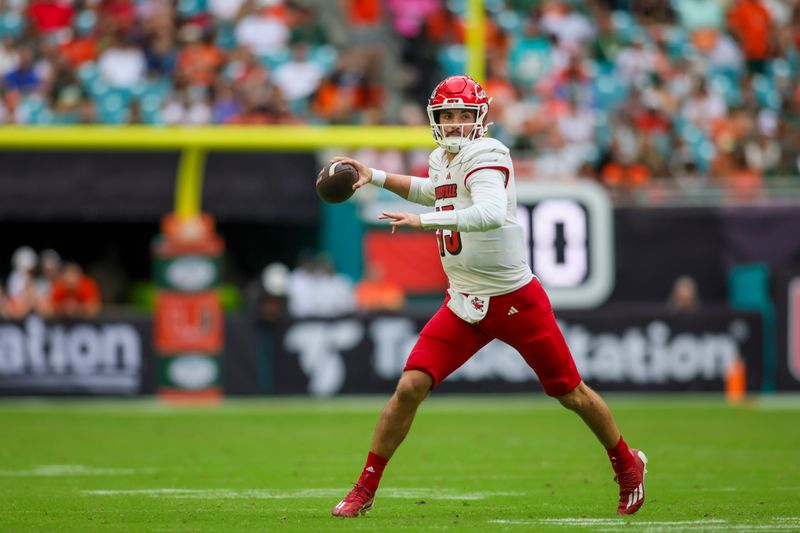 Nov 18, 2023; Miami Gardens, Florida, USA; Louisville Cardinals quarterback Jack Plummer (13) looks for a passing option against the Miami Hurricanes during the fourth quarter at Hard Rock Stadium. Mandatory Credit: Sam Navarro-USA TODAY Sports