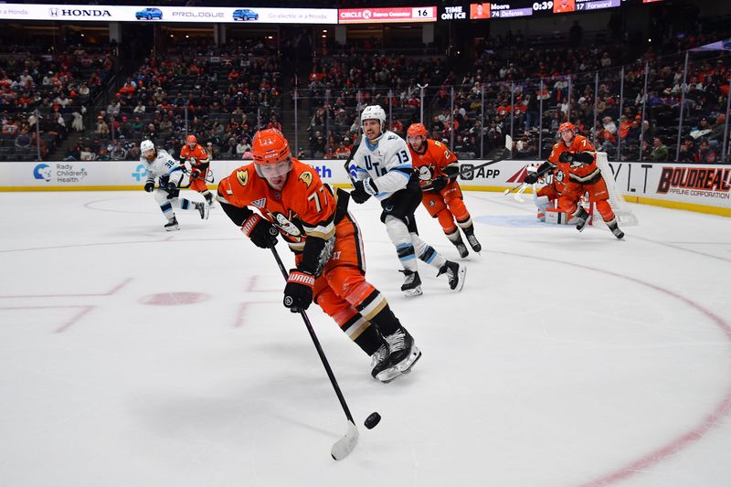 Nov 17, 2025; Anaheim, California, USA; Anaheim Ducks right wing Frank Vatrano (77) moves the puck ahead of Utah Mammoth left wing Brandon Tanev (13) during the third period at Honda Center. Mandatory Credit: Gary A. Vasquez-Imagn Images